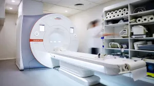 Modern examination room with X-ray equipment and monitors.